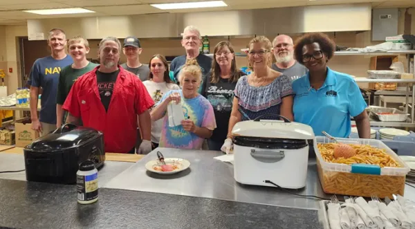 A group of UAW Local 2000 members gathers around the kitchen, preparing the meal that will serve as a fundraiser for local law enforcement.